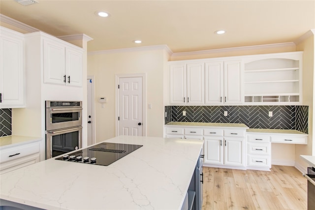 kitchen featuring light stone counters, decorative backsplash, stainless steel double oven, and white cabinets