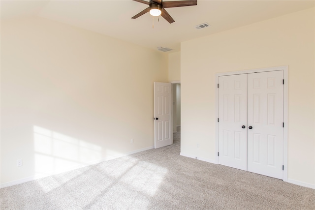 unfurnished bedroom featuring light carpet, a closet, and ceiling fan