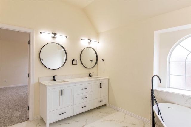 3004 Normandy Dr, Mckinney, TX 75070 - full bathroom featuring double vanity, a freestanding bath, marble finish floors, vaulted ceiling, and baseboards