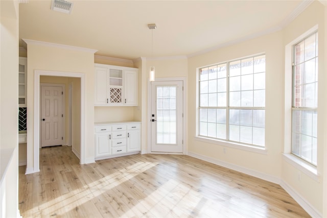 interior space with ornamental molding and light hardwood / wood-style flooring