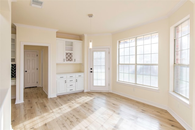 3004 Normandy Dr, Mckinney, TX 75070 - unfurnished dining area featuring light wood-style floors, crown molding, and baseboards