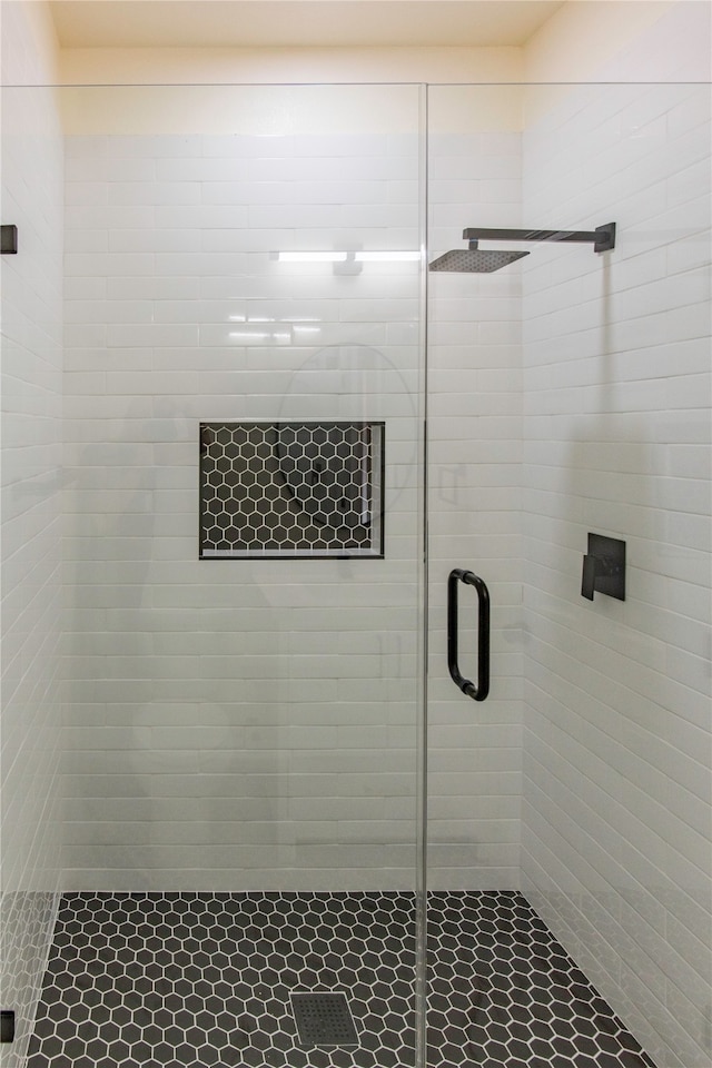 bathroom featuring a shower with shower door and tile patterned flooring