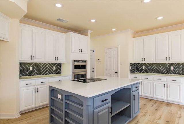 kitchen with white cabinetry, light hardwood / wood-style flooring, a center island, and double oven