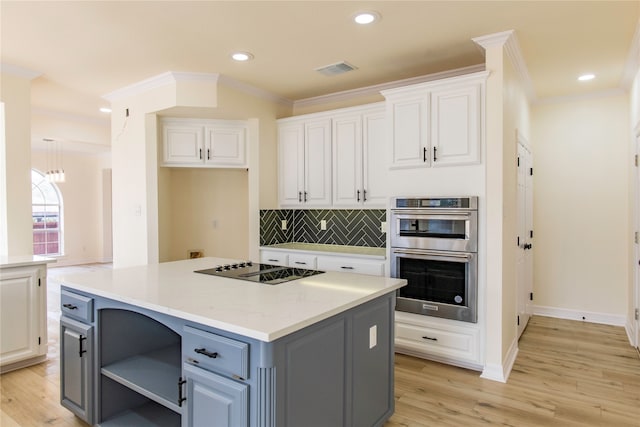 kitchen with tasteful backsplash, a center island, stainless steel double oven, white cabinetry, and light hardwood / wood-style floors