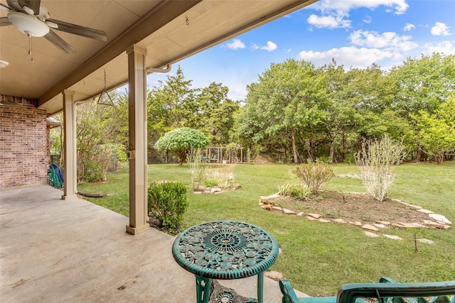 view of yard with ceiling fan and a patio