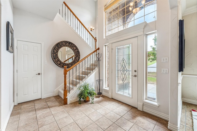 foyer entrance featuring light tile patterned flooring and a high ceiling