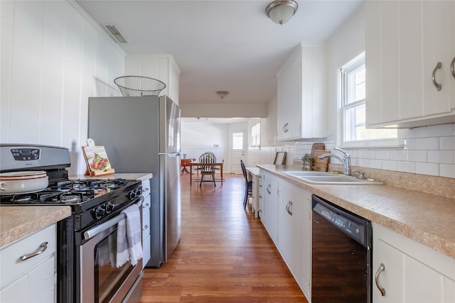 kitchen with white cabinetry, a healthy amount of sunlight, stainless steel appliances, and sink