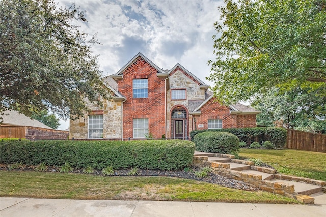 5916 Lavon Dr, Flower Mound, TX 75028 - traditional-style house featuring fence, a front yard, brick siding, and stone siding