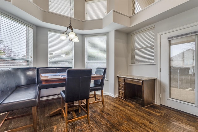 dining space with dark hardwood / wood-style flooring and a high ceiling