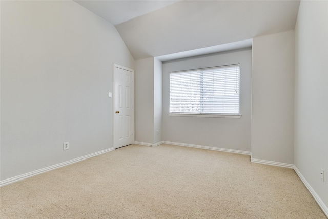 unfurnished room with light carpet and vaulted ceiling