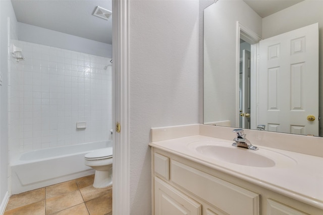 full bathroom featuring vanity, tiled shower / bath, tile patterned flooring, and toilet