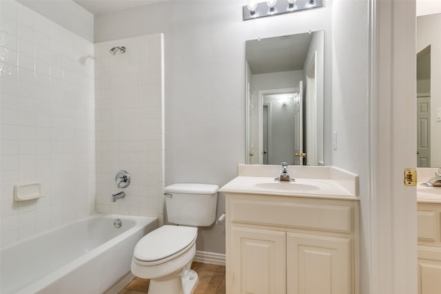 full bathroom featuring tiled shower / bath combo, vanity, and toilet