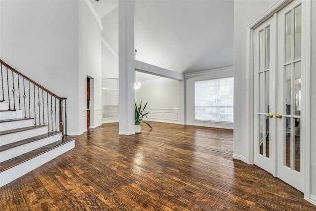 unfurnished living room with ornamental molding, dark wood-type flooring, and high vaulted ceiling