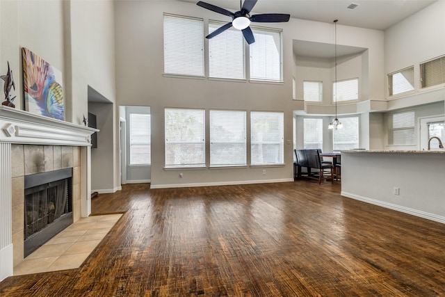 unfurnished living room featuring hardwood / wood-style flooring, plenty of natural light, and a tile fireplace