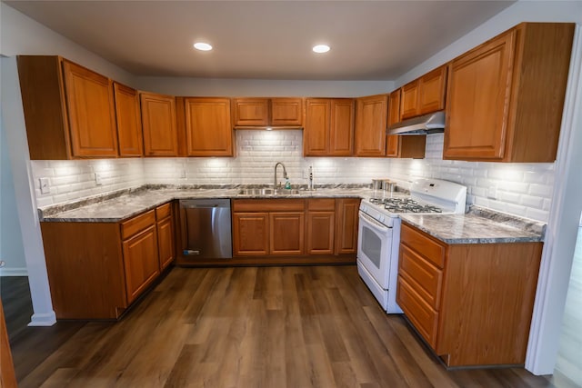 kitchen featuring dishwasher, dark stone counters, sink, dark hardwood / wood-style floors, and white gas stove