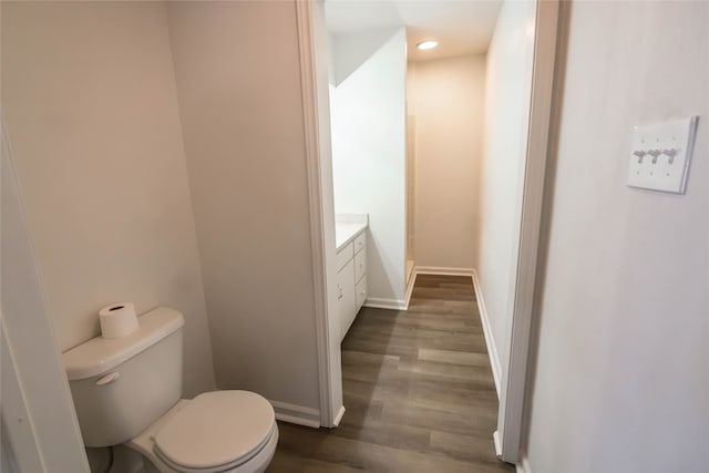 bathroom featuring wood-type flooring, vanity, and toilet