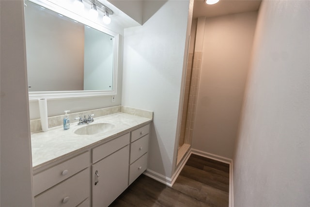 bathroom with a shower, vanity, and wood-type flooring