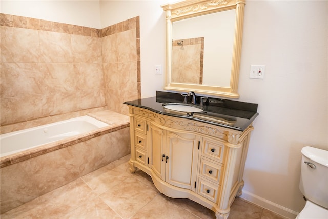 bathroom featuring tiled tub, vanity, and toilet