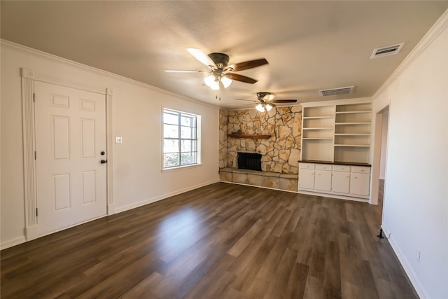 unfurnished living room featuring ceiling fan, built in features, a fireplace, ornamental molding, and dark hardwood / wood-style flooring