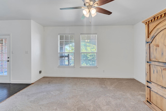 empty room with dark hardwood / wood-style floors, plenty of natural light, and ceiling fan