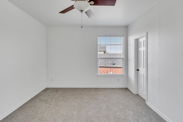 carpeted spare room with ceiling fan