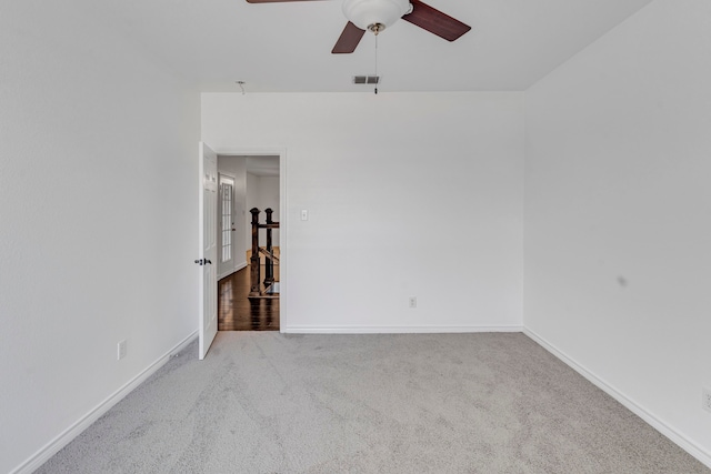 spare room featuring light colored carpet and ceiling fan