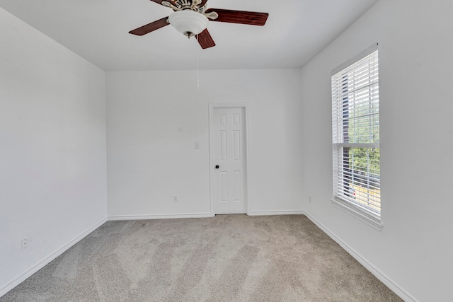 carpeted spare room with ceiling fan