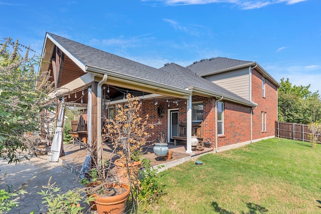 rear view of house featuring a patio area and a lawn