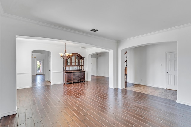 spare room featuring crown molding and a chandelier