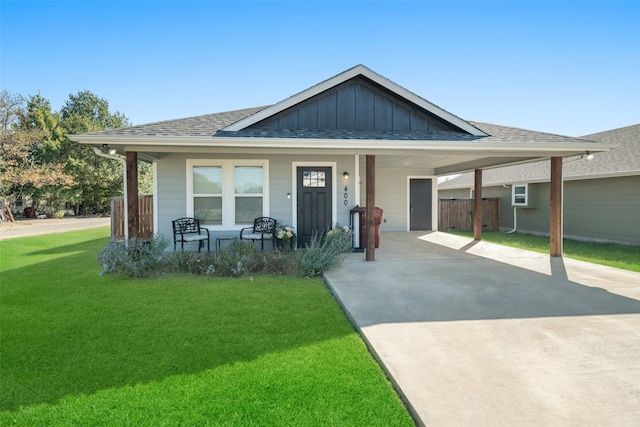 view of front of property with covered porch, a front lawn, and a carport