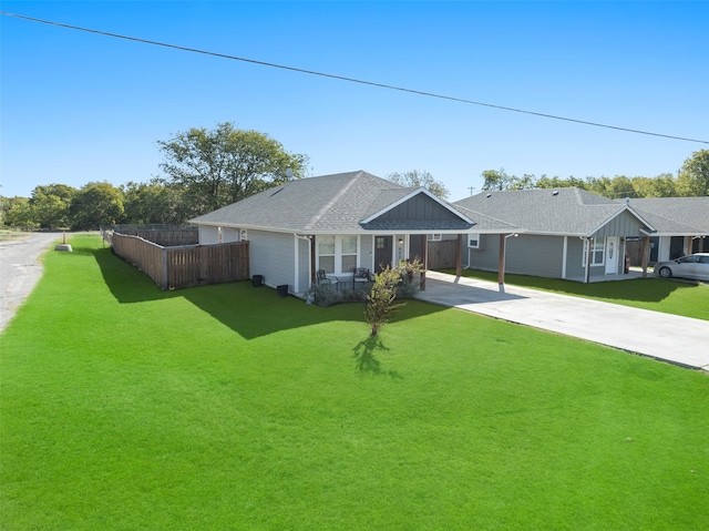 ranch-style home featuring fence, a front lawn, a shingled roof, and driveway