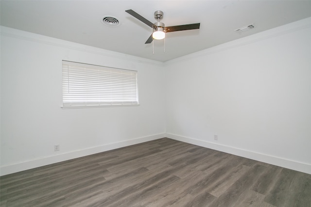 spare room with dark wood-type flooring, crown molding, and ceiling fan