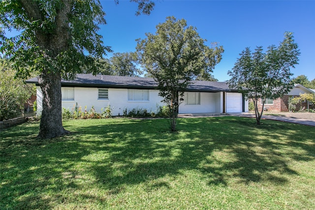 ranch-style home featuring a garage and a front lawn