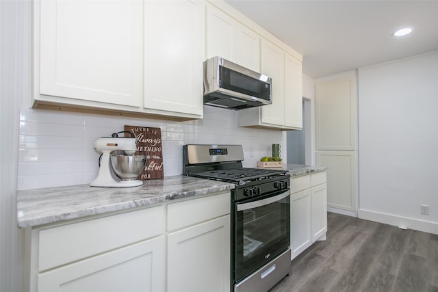 kitchen featuring white cabinetry, hardwood / wood-style floors, stainless steel appliances, and backsplash