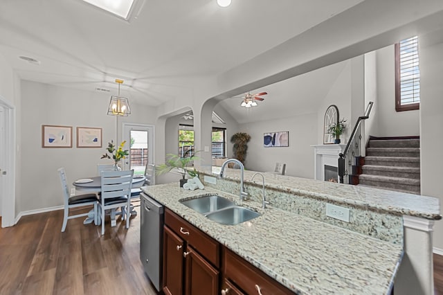 kitchen with ceiling fan with notable chandelier, a kitchen island with sink, sink, pendant lighting, and dishwasher