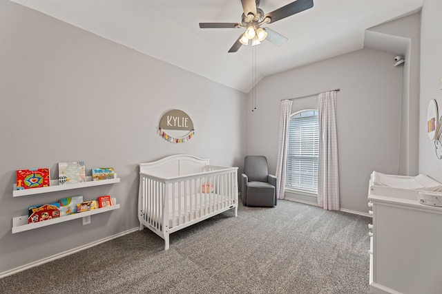 carpeted bedroom with ceiling fan, a nursery area, and lofted ceiling