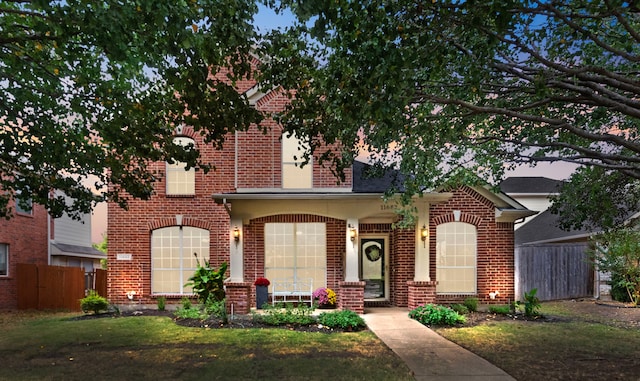 view of front of house with covered porch and a yard