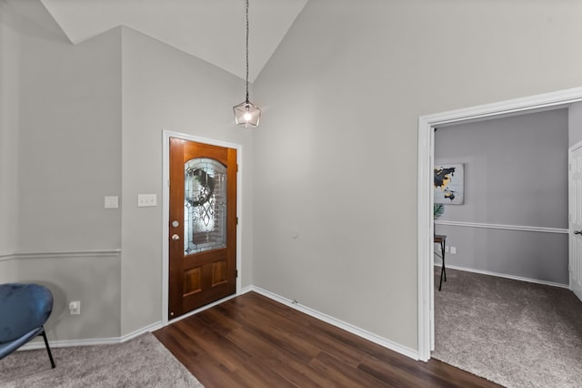 carpeted foyer entrance with high vaulted ceiling