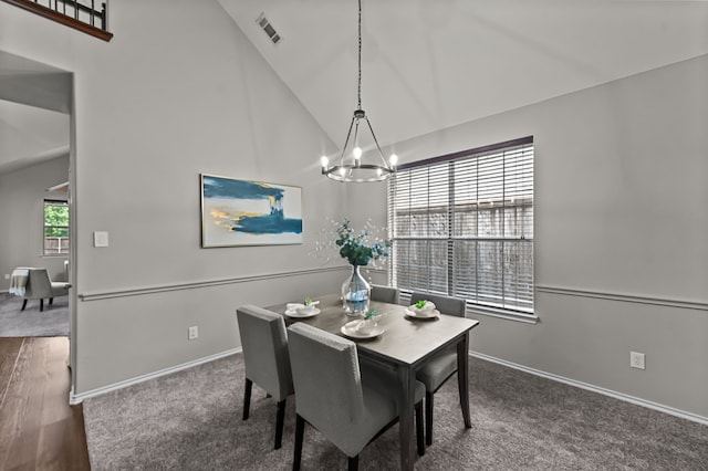 dining area featuring high vaulted ceiling and an inviting chandelier