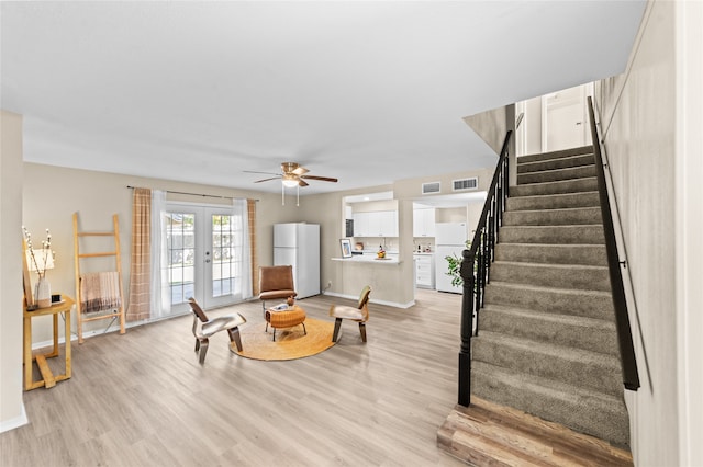 living room featuring french doors, light hardwood / wood-style floors, and ceiling fan