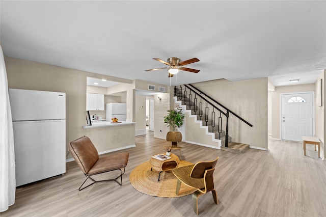 living area with ceiling fan and light hardwood / wood-style flooring