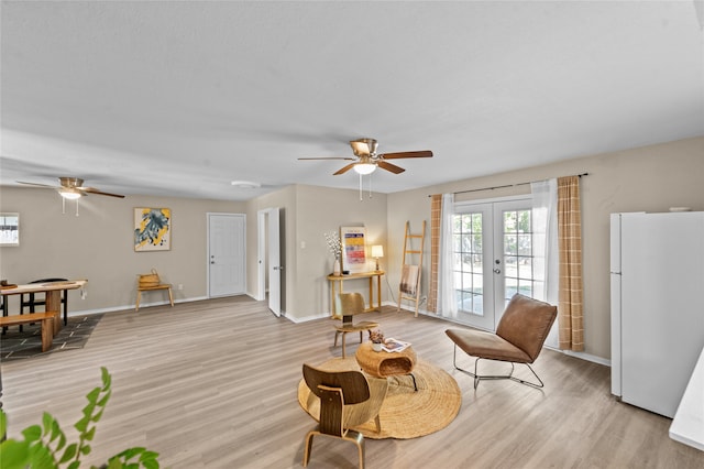 living room featuring french doors, light wood-type flooring, and ceiling fan