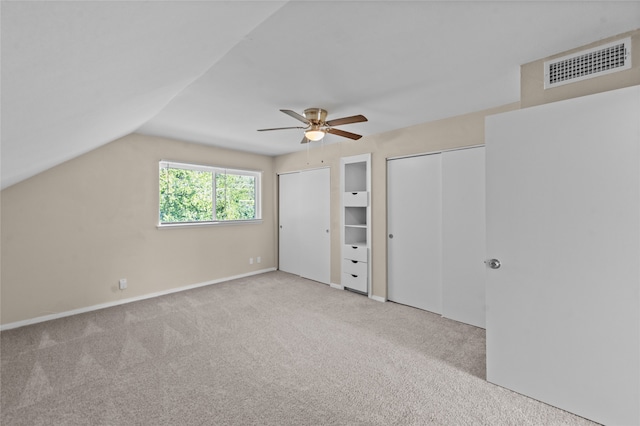 interior space with ceiling fan, light colored carpet, and vaulted ceiling