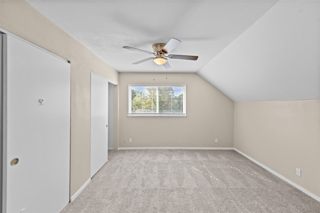 additional living space with vaulted ceiling, light carpet, and ceiling fan