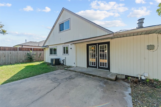 back of house featuring central AC unit, a patio area, and a lawn