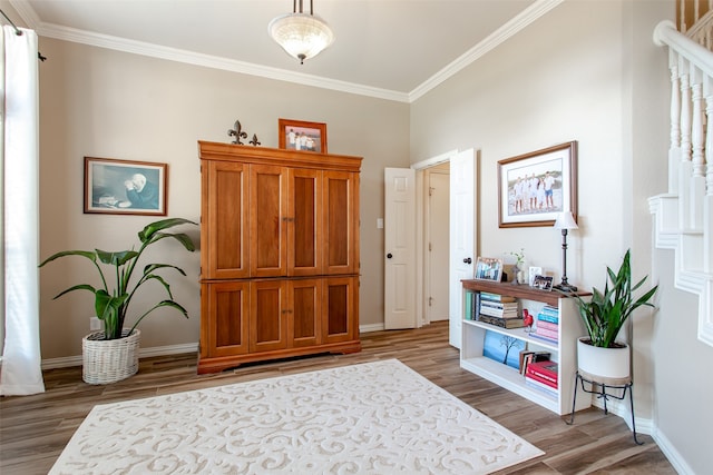 living area with ornamental molding and hardwood / wood-style floors