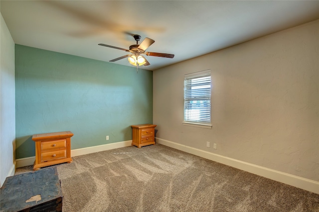 unfurnished room featuring ceiling fan and carpet