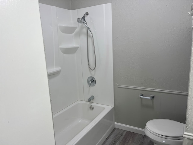 bathroom with toilet, shower / washtub combination, and hardwood / wood-style floors