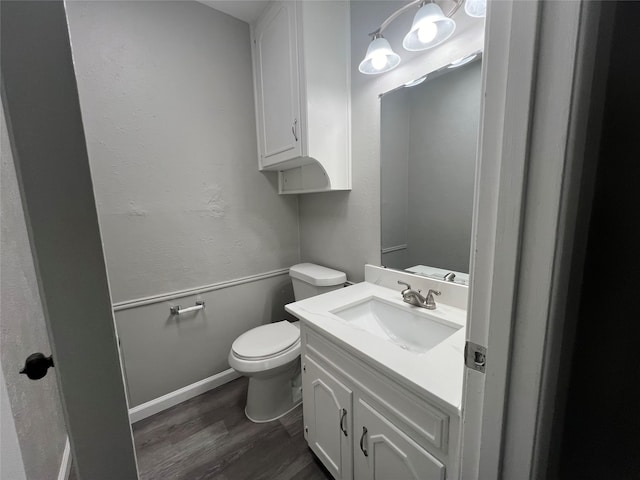 bathroom featuring toilet, hardwood / wood-style floors, and vanity