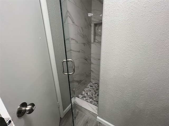 bathroom featuring a shower with door